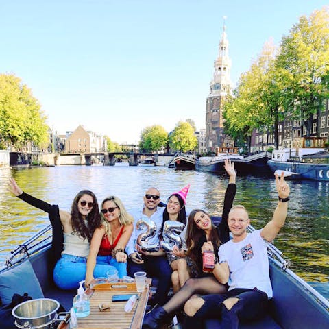 a birthday party group on an open boat tour in amsterdam