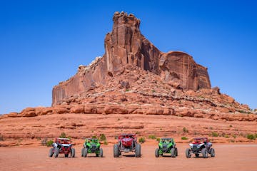 a group of people on a motorcycle in the desert with Bell Rock in the background