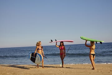 a person carrying a surf board on a beach