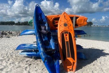 a blue and orange boat sitting on top of a beach