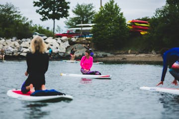 People on paddleboards practice a relaxing yoga pose
