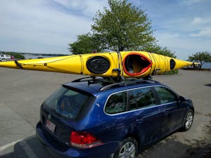 A kayak strapped to the roof of a car for transport