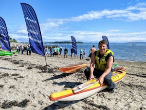 A person sitting on the beach on their kayak at the startline for a race
