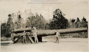 a vintage photo of three men standing in front of a large cannon