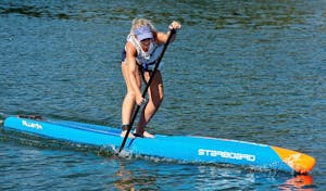 A woman on a narrow racing paddleboard