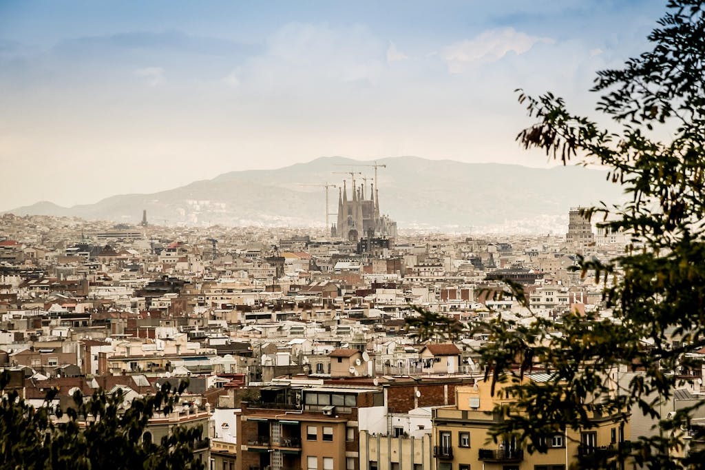 a view of Barcelona city with the Sagrada Familia and the hills in the background