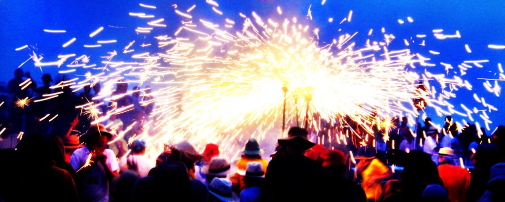 A group of people performing Correfoc with fireworks.