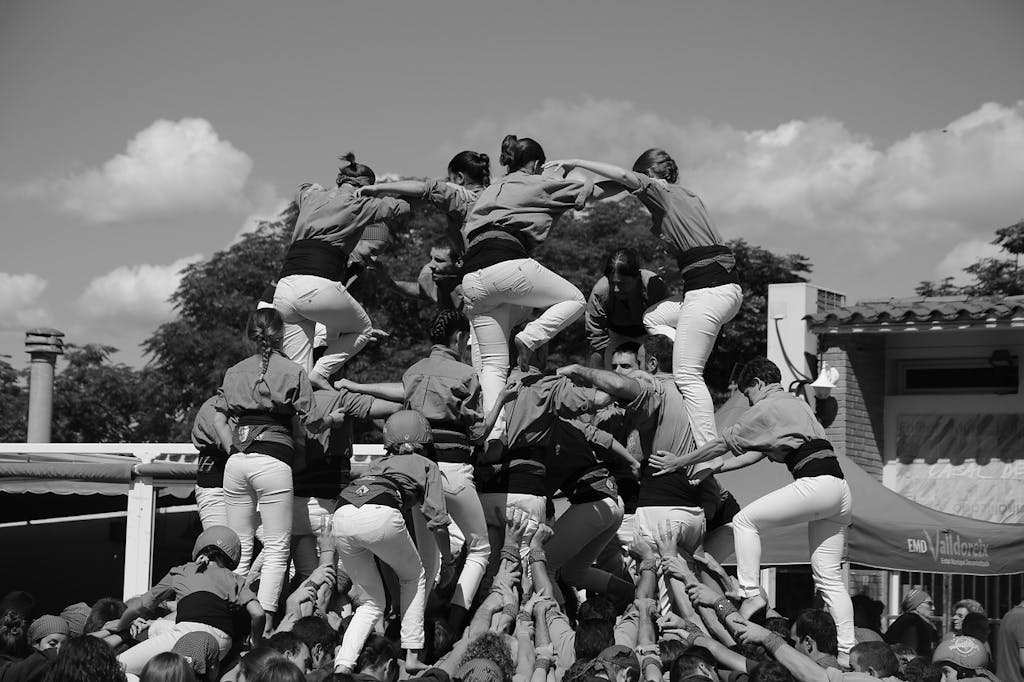 A group of people building a tower to perform Castellers during the street festival in Barcelona.