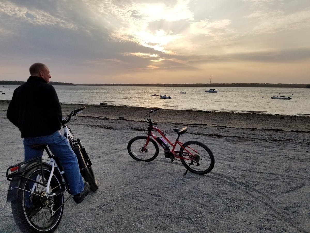 a man riding a bicycle next to a body of water