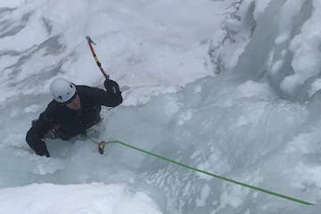 a person climbing up a snow covered slope