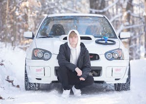 a man sitting on top of a snow covered car