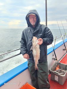 a man holding a fish on a boat