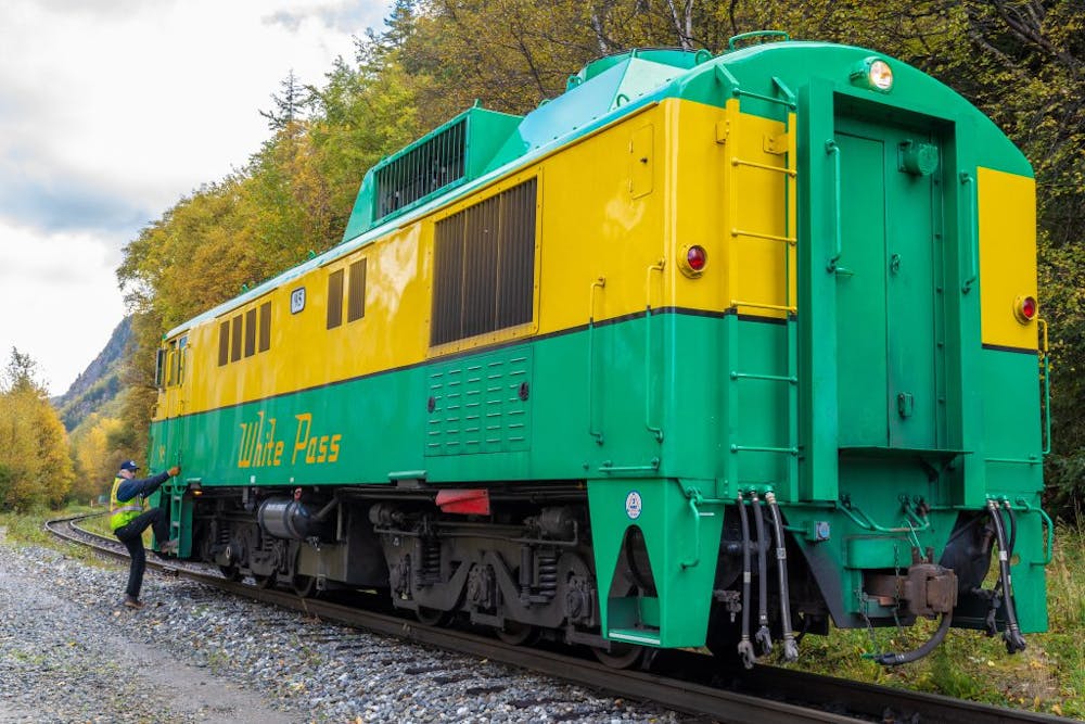 a green train that is sitting on a track