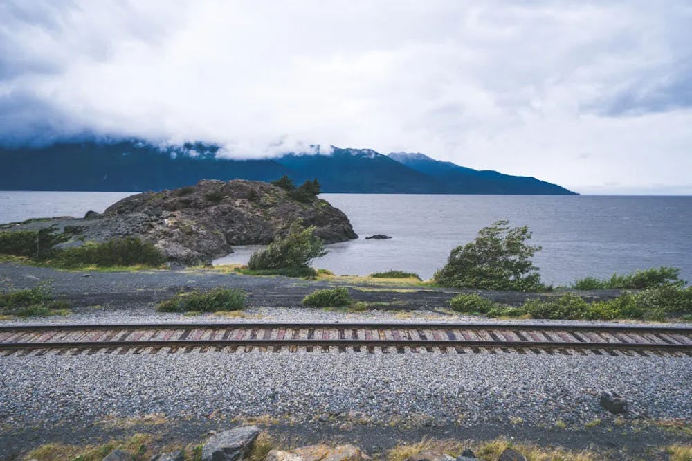 a train traveling down train tracks next to a body of water