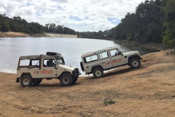 two jeeps parked near a body of water