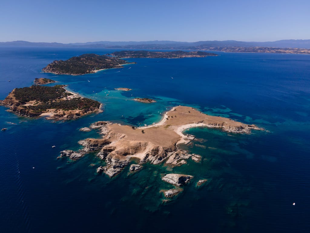 Aerial view of Ammouliani and Drenia Islands surrounded by crystal-clear waters and lush greenery.