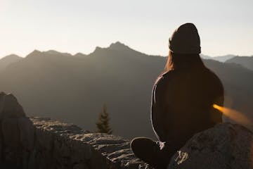 a person meditating on the mountain