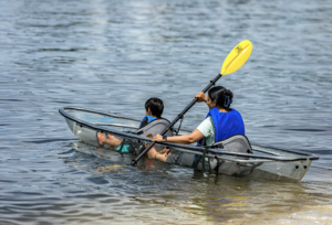 A mother and son paddling in a kayak in Grand Lagoon