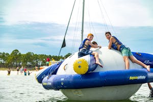 Three boys playing on an inflatable toy at Shell Island on our Adventure Tour