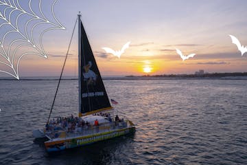 Paradise Adventures catamaran Privateer sailing at sunset. Graphic has halloween spider and bats for effect.