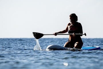 a person rowing a paddleboard in the water