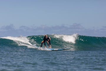 a woman riding a wave on a surfboard in the ocean