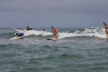 a group of people riding a wave on a surfboard in the ocean