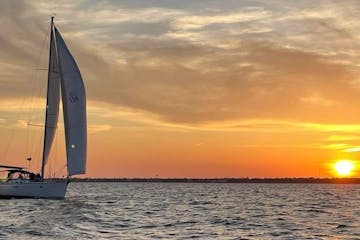 a sailboat on a body of water during sunset