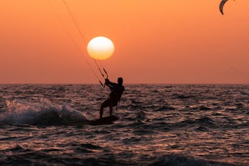 a group of people kiteboarding in a body of water