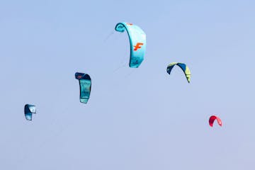 a group of people flying kites in the air