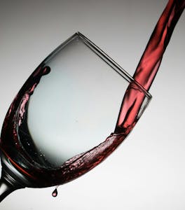 Glass of red wine being poured, showcasing Porto's rich wine culture