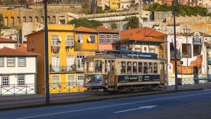 The iconic historic Tram number 1 traverses through Porto's charming historic area, surrounded by colorful buildings.
