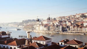 A panoramic view from Gaia showcases the Cable Car, wine cellars, Douro River, and Porto's skyline.