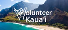 Volunteer Kauai sign on the side of a mountain next to a beach