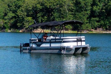 a man driving a 21' pontoon on a lake