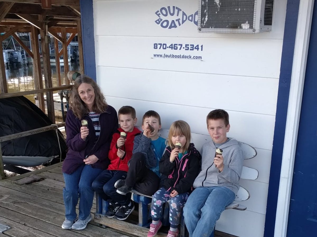 a group of kids posing for the camera while eating ice cream