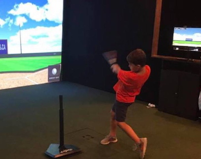 a young boy standing in front of a television playing a video game
