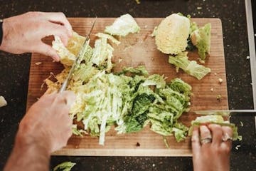 a person slicing a vegetable on a cutting board