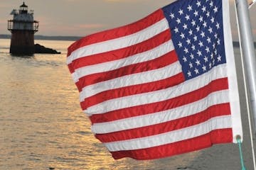 a close up of a flag next to a body of water