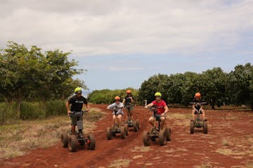 a group of people riding a motorcycle down a dirt road