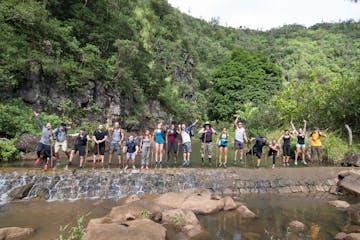 a group of people standing next to a river
