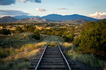 a train on a train track with a mountain in the background