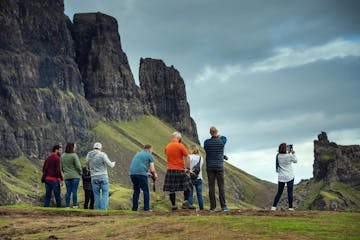 A Hairy Coo tour group taking photos of the mountains and scenery on the Isle of Skye