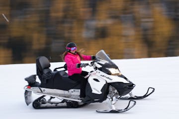 a person riding a snowmobile in the snow