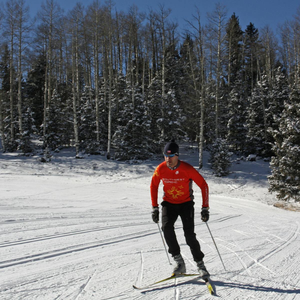 a man is cross country skiing on a snow covered slope