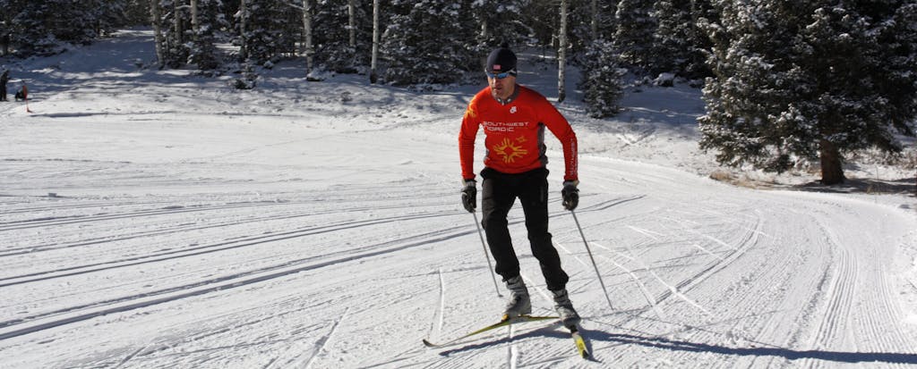 a man is cross country skiing on a snow covered slope