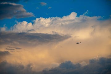 a plane flying through a cloudy sky