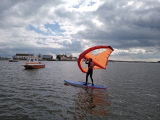 a person flying a kite in a boat on the water