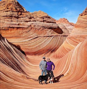 a person riding on the back of a canyon with Vermilion Cliffs National Monument in the background
