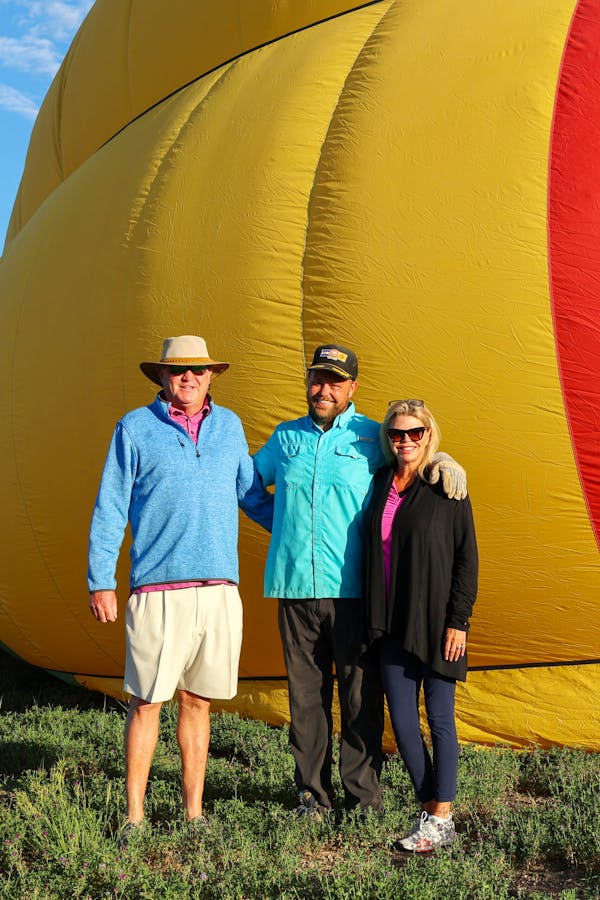 a group of people posing for the camera in front of pagosa adventure's hot air balloon in pagosa springs, colorado